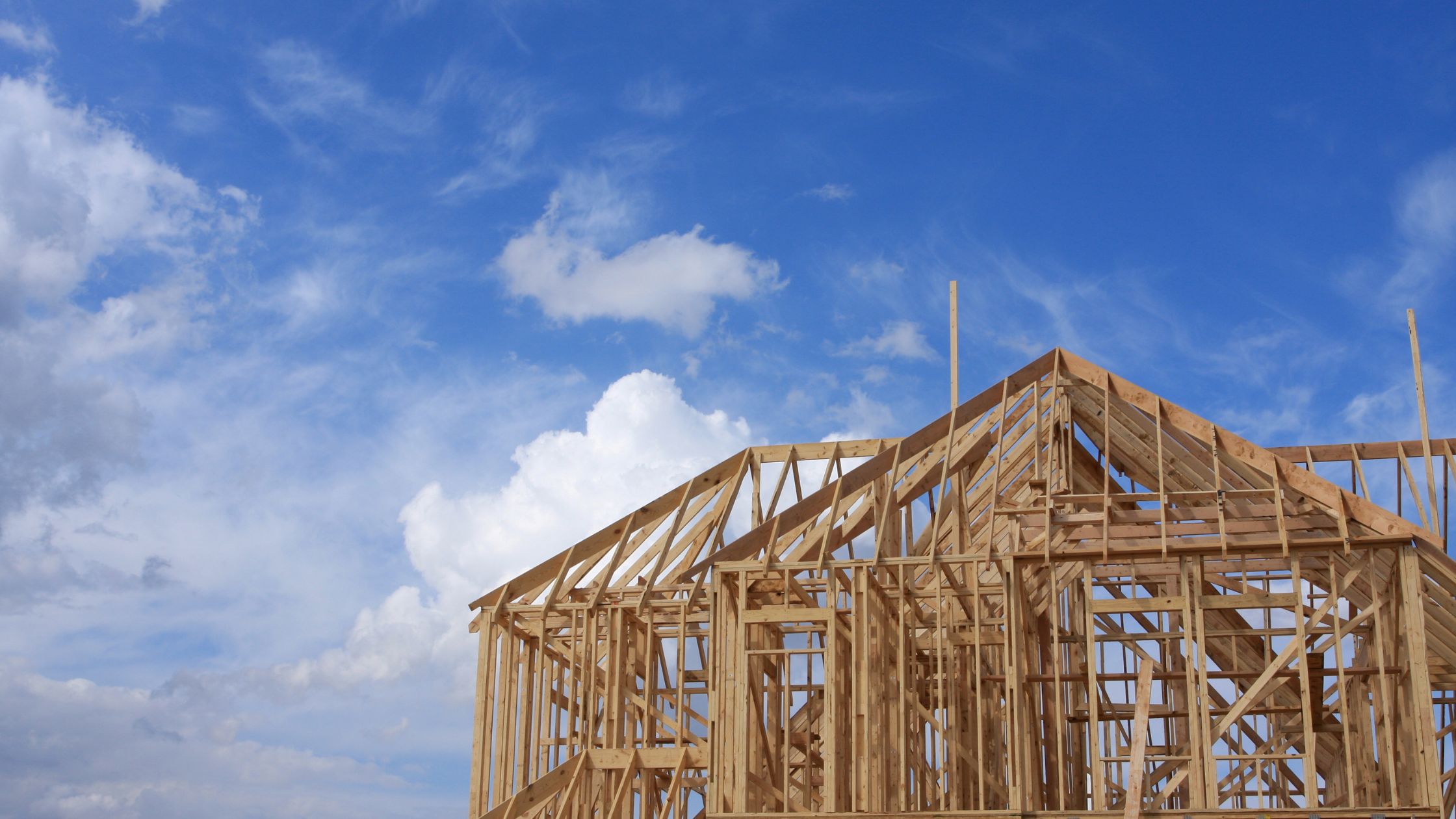 Wooden house frame under blue sky