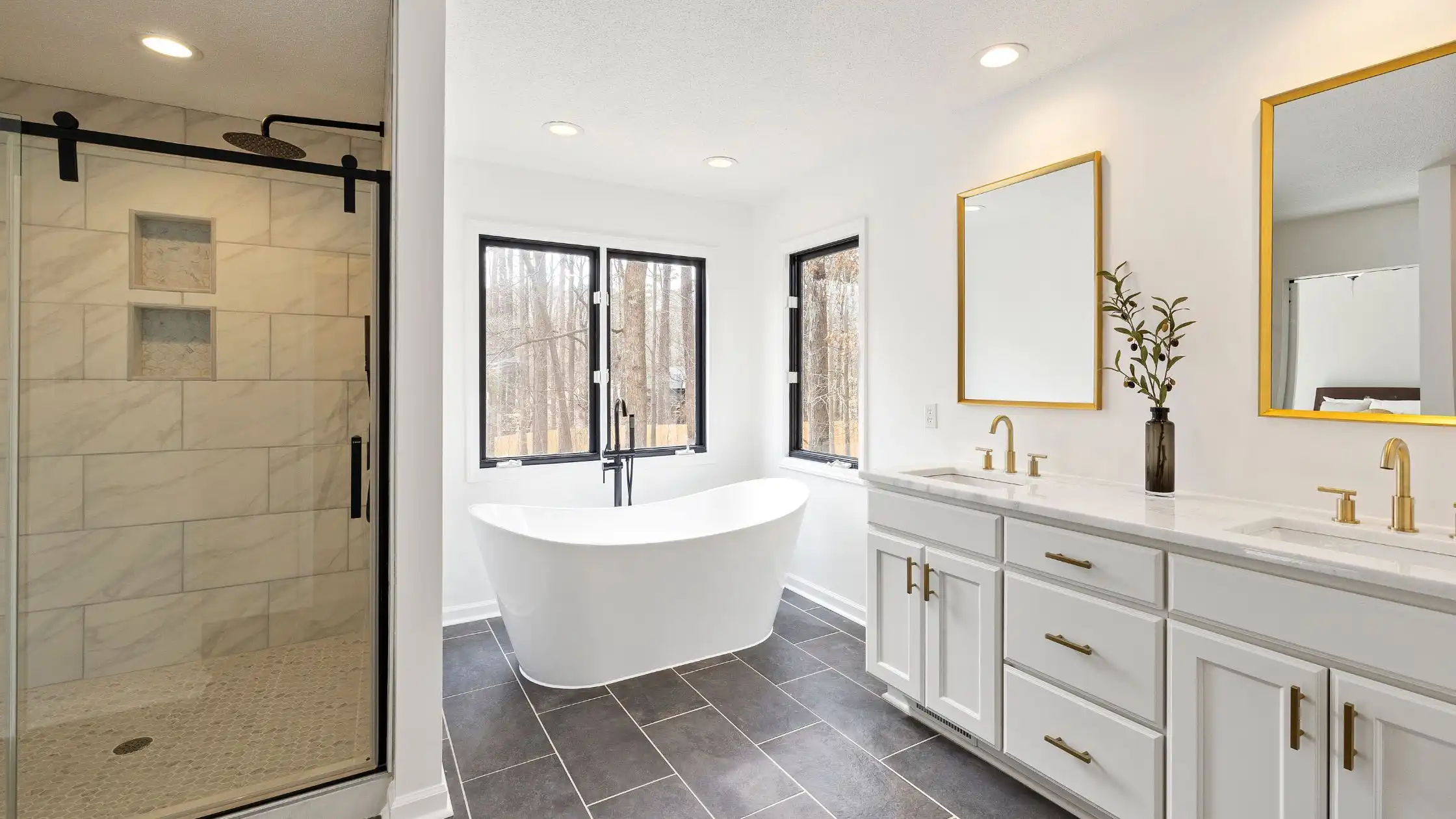 Modern bathroom with bathtub and dual sinks.