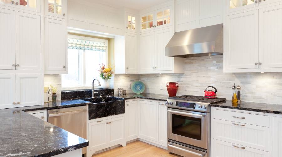Modern white kitchen with black countertops.