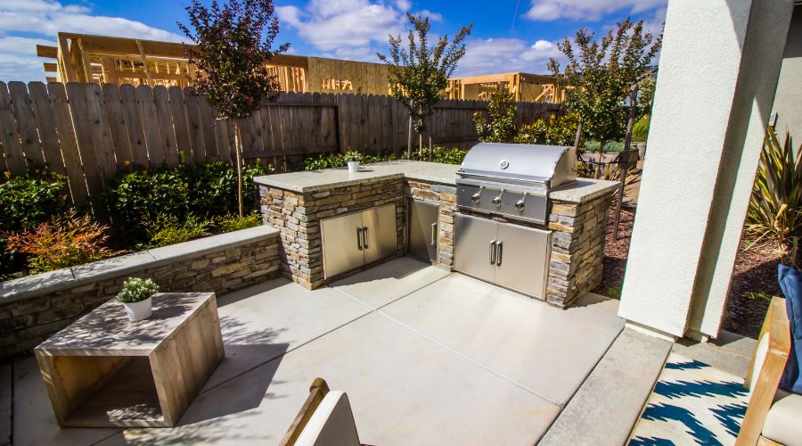 Outdoor patio with BBQ grill and stone cabinetry.