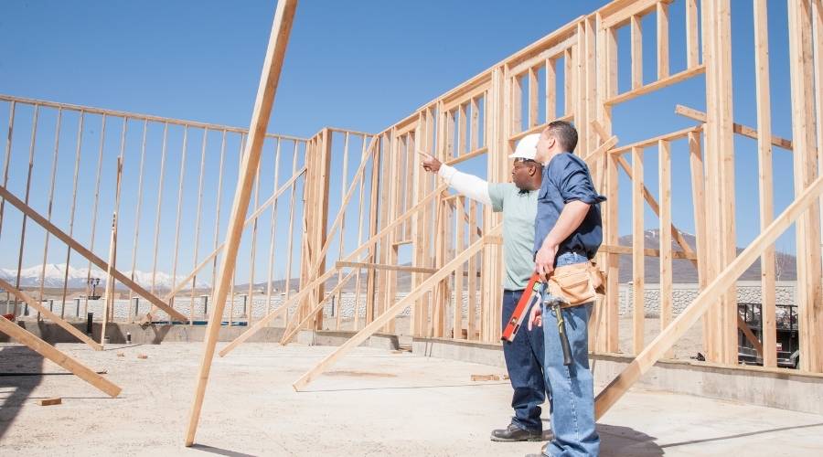Construction workers planning building project on site.