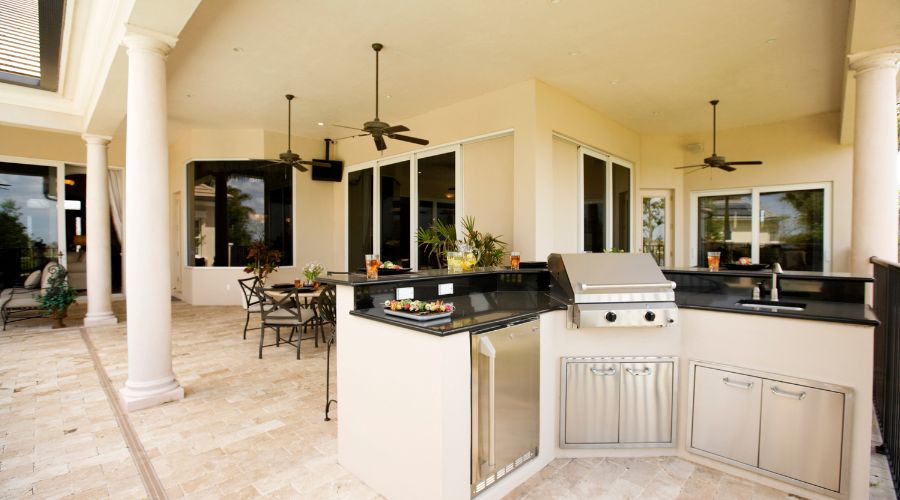 Luxurious outdoor kitchen with grill and dining area.