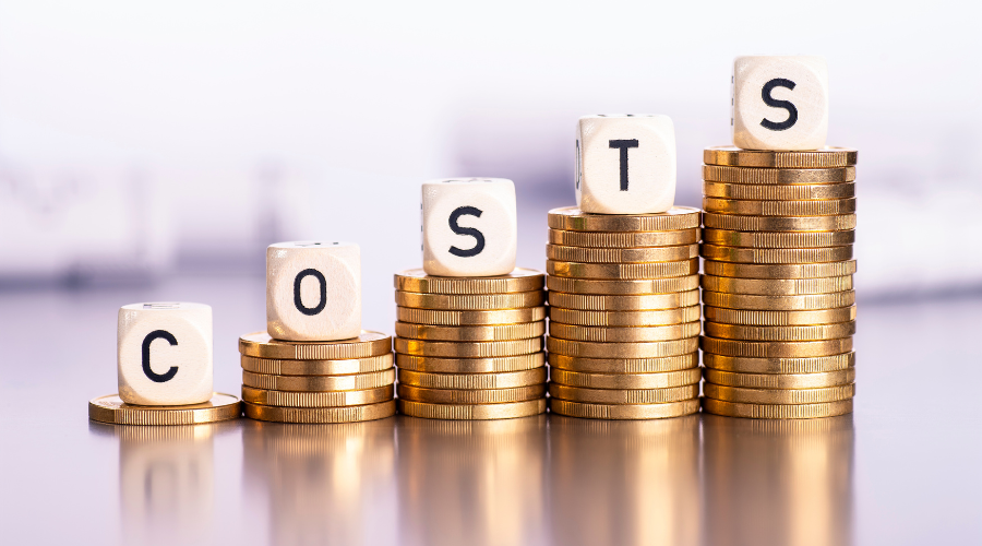 Stacks of coins with dice spelling 'COSTS'.
