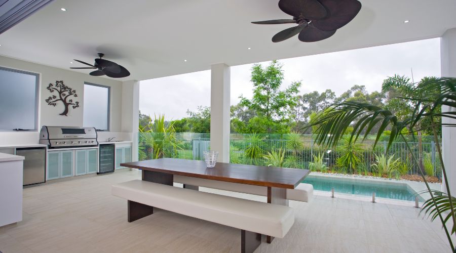 Outdoor patio with dining table and pool view.