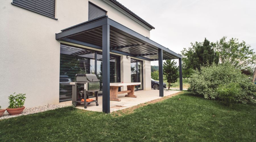 Modern patio with metal pergola and grill area.