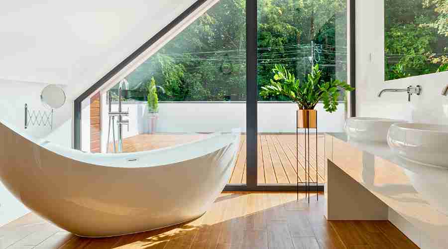 Modern bathroom with freestanding tub and large window.